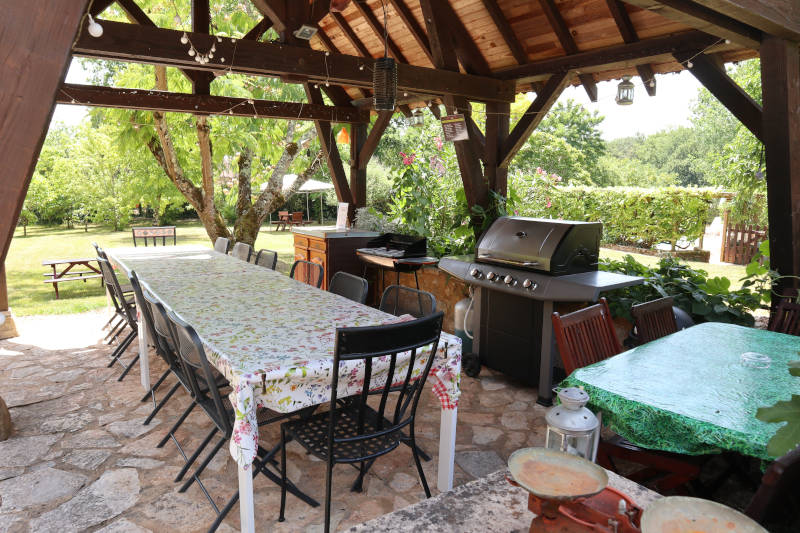 large shedded area with table , chairs and a BBQ